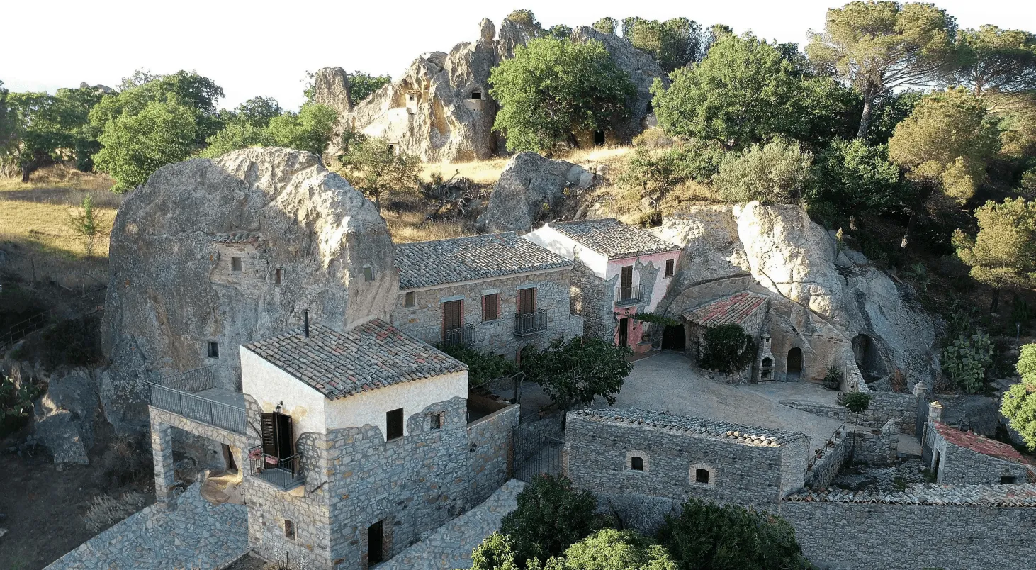 Vista aerea drone della masseria fra la roccia e il bosco mediterraneo