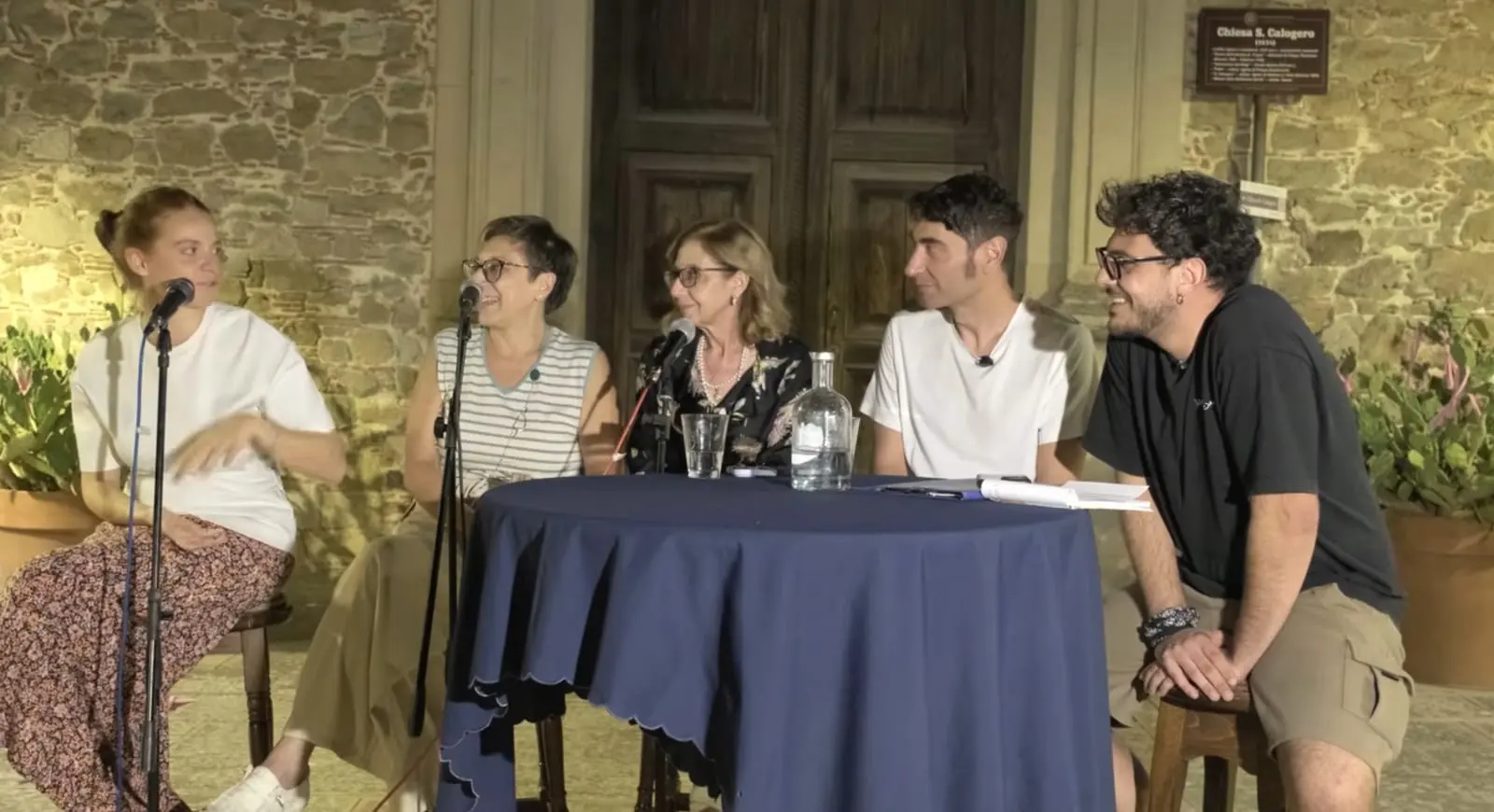 La registrazione della prima puntata, di sera, davanti al portone della chiesa di San Calogero a Nicosia: cinque persone sedute attorno a un tavolino con la tovaglia blu, fra microfoni ad asta e a clip.