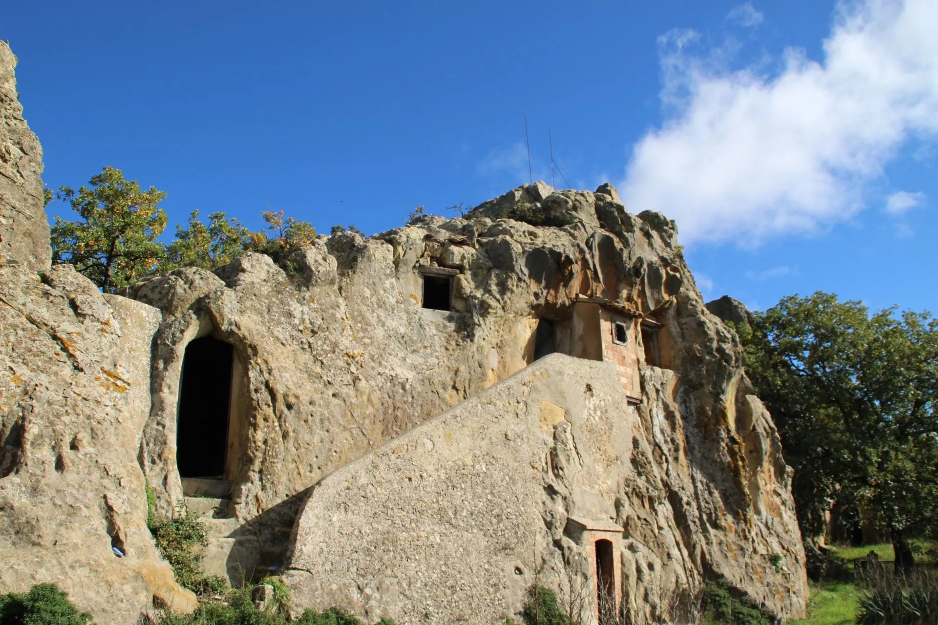 Facciata rupestre con apertura scavata e scala in pietra