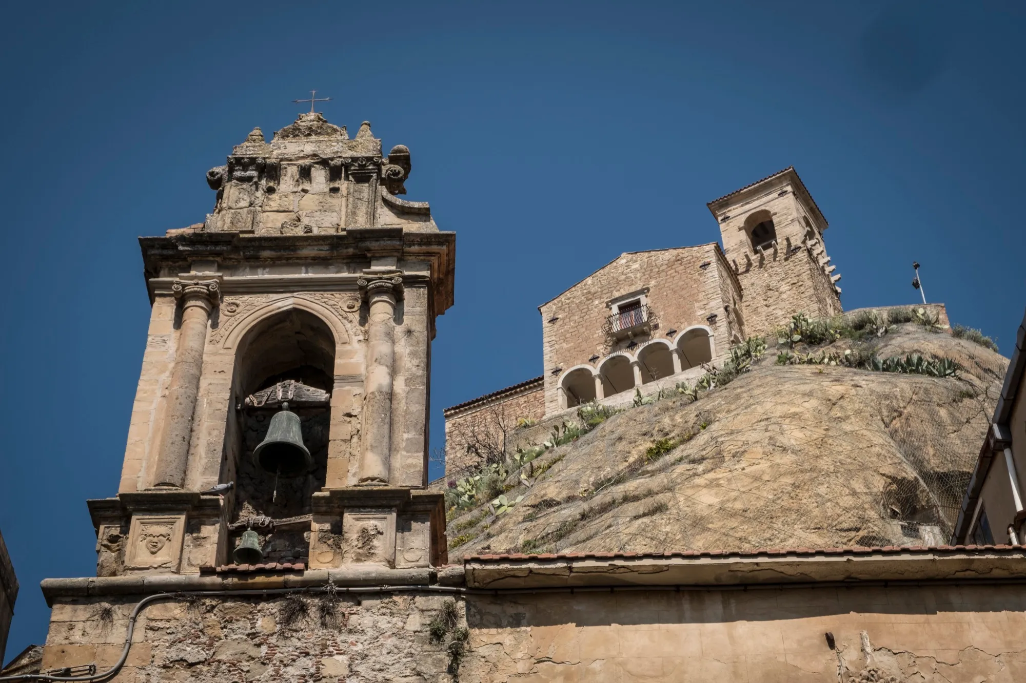 La chiesa sulla rupe vista dal basso, col campanile a vela di Sant'Antonio Abate in primo piano